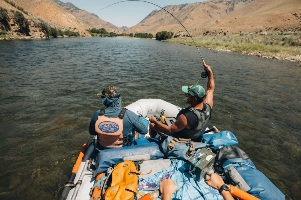 Angler fighting a fish from an MFRT raft on the Middle Fork of the Salmon River